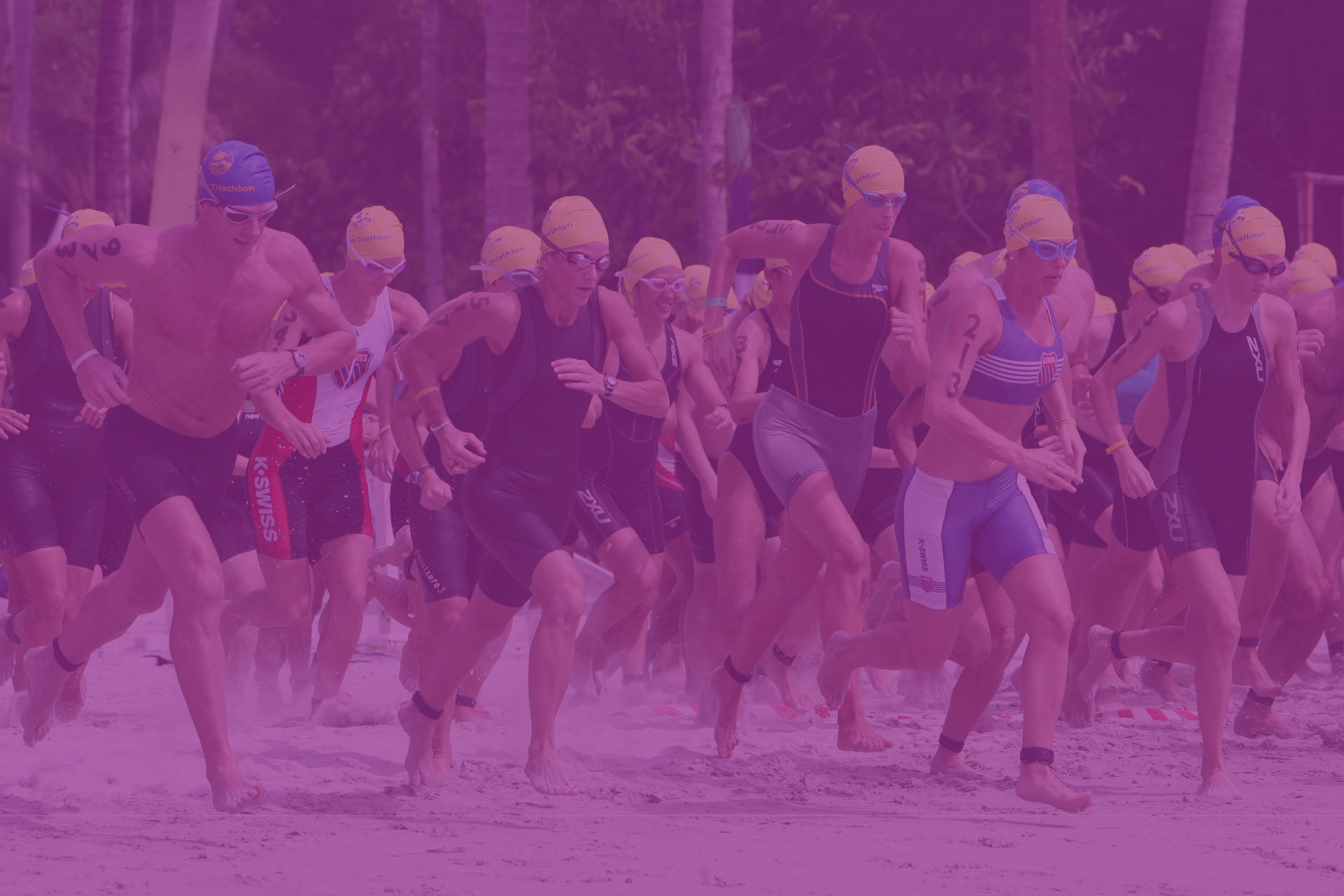 Participantes de un triatlón saliendo corriendo en la playa durante una prueba en Gran Canaria