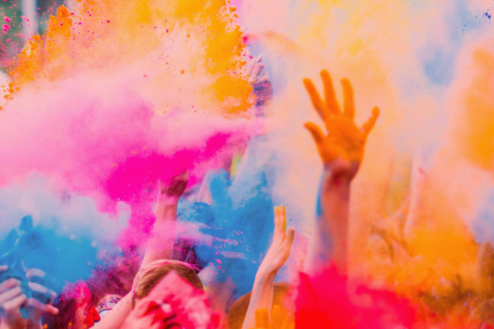Personas lanzando polvos de colores al aire en una carrera de color en Gran Canaria
